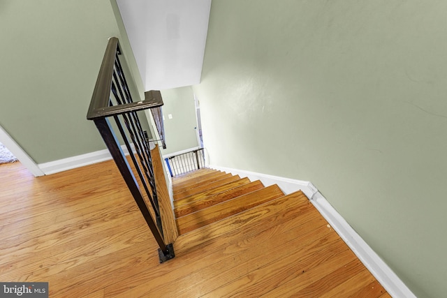 stairway with baseboards and wood finished floors