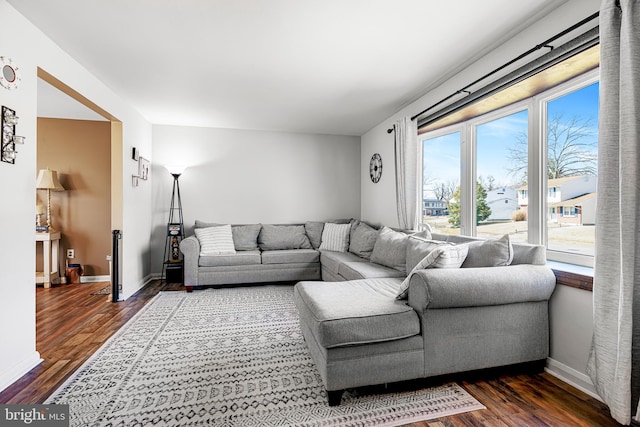 living area featuring dark wood-type flooring and baseboards