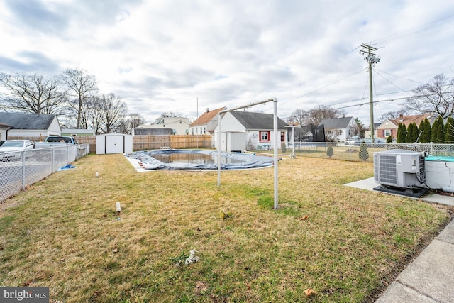 view of yard featuring a shed, an outbuilding, cooling unit, and a fenced backyard