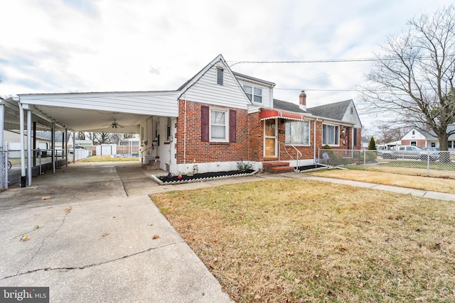 view of front of home featuring driveway, brick siding, a front lawn, and fence