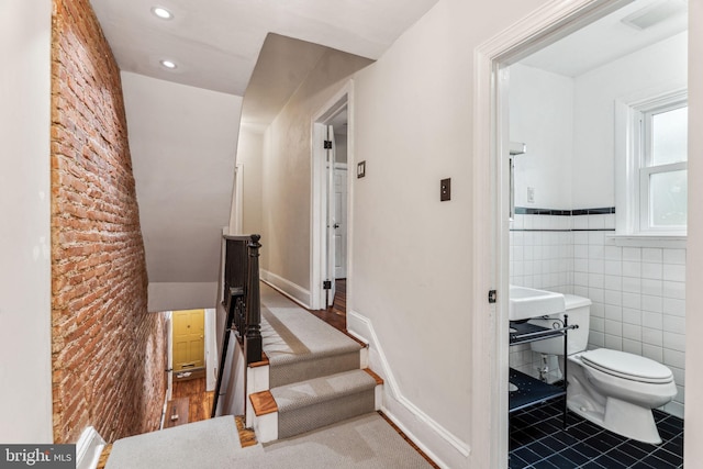 interior space with toilet, recessed lighting, a wainscoted wall, tile walls, and tile patterned floors