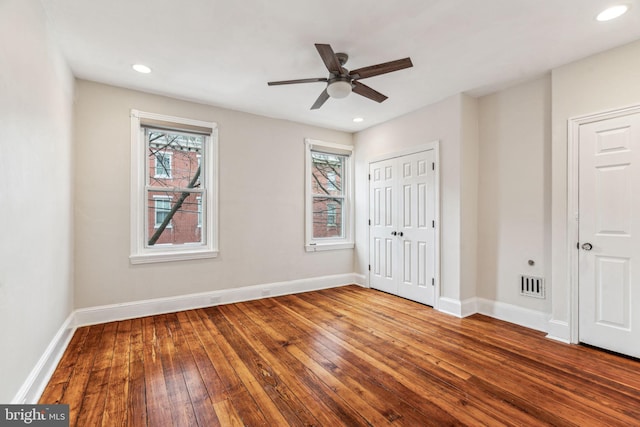 unfurnished bedroom with baseboards, visible vents, hardwood / wood-style floors, and recessed lighting