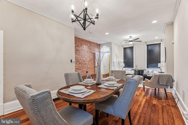 dining area featuring ornamental molding, baseboards, hardwood / wood-style floors, and ceiling fan with notable chandelier