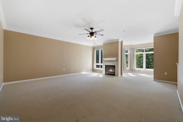 unfurnished living room with a fireplace with flush hearth, ornamental molding, baseboards, and light colored carpet