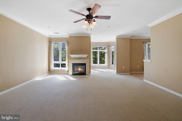 unfurnished living room with visible vents, baseboards, a glass covered fireplace, light colored carpet, and ornamental molding