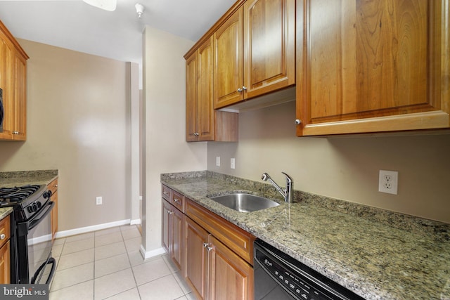 kitchen with light tile patterned floors, baseboards, light stone counters, black appliances, and a sink