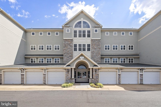 townhome / multi-family property with stone siding and french doors