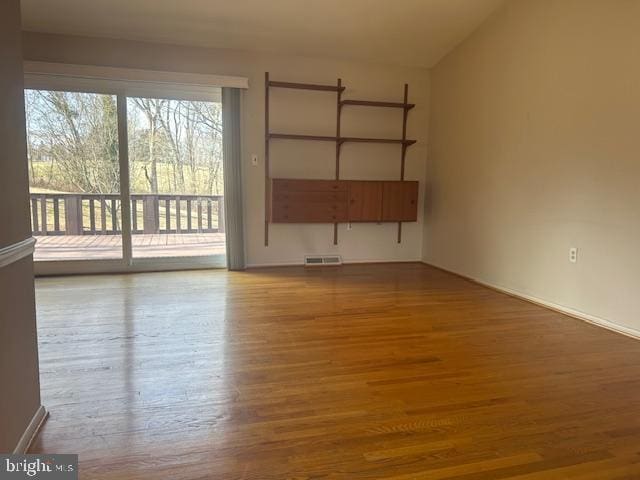 unfurnished living room with visible vents and wood finished floors