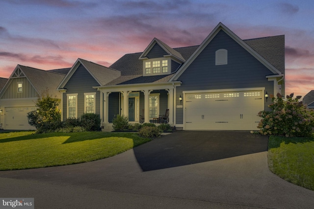 craftsman inspired home with driveway, a garage, a porch, and a lawn