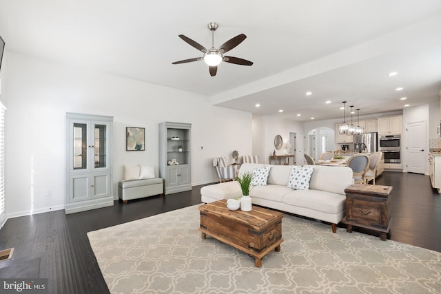 living area with arched walkways, dark wood-style flooring, ceiling fan, and recessed lighting