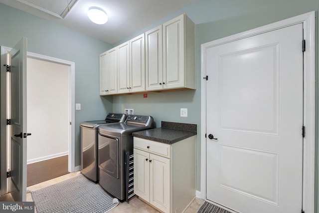 washroom with cabinet space, independent washer and dryer, and baseboards