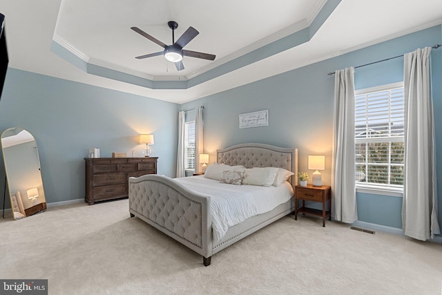 bedroom with carpet, a raised ceiling, visible vents, ornamental molding, and baseboards