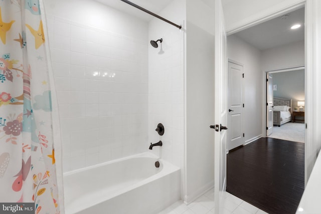 bathroom featuring baseboards, shower / bath combo, and tile patterned floors