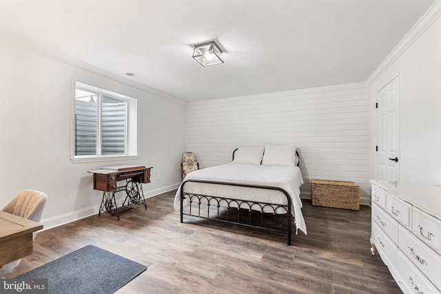 bedroom with ornamental molding, dark wood-style flooring, visible vents, and baseboards