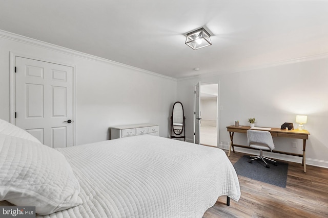 bedroom featuring ornamental molding, baseboards, and wood finished floors