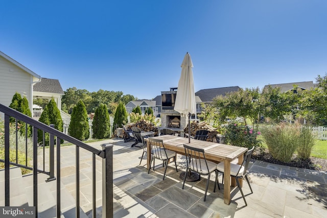 view of patio / terrace featuring an outdoor stone fireplace and outdoor dining area