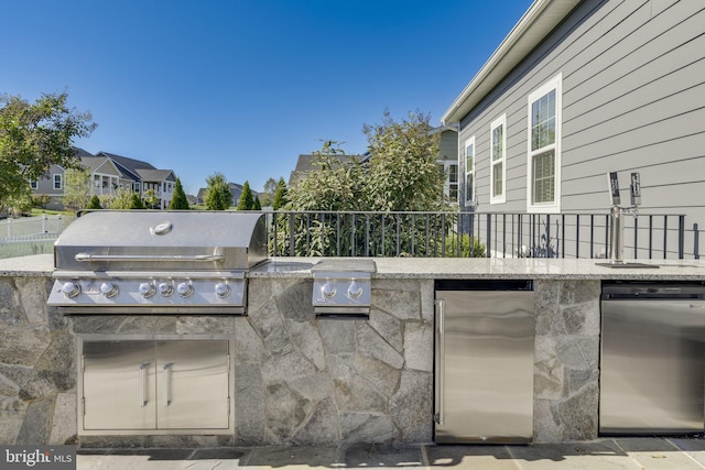 view of patio / terrace with an outdoor kitchen, fence, and grilling area