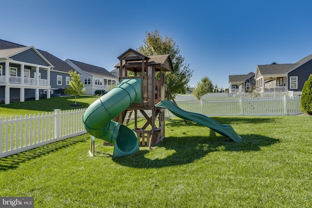 view of playground featuring a residential view, fence, and a yard