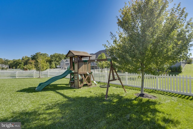 view of playground with fence and a lawn