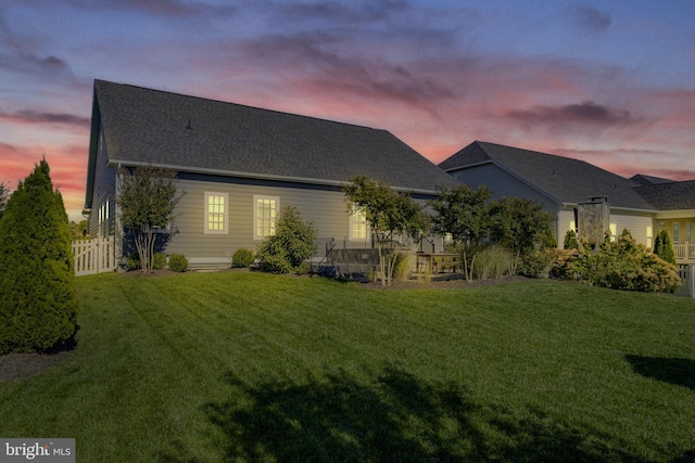 back of house featuring fence and a lawn