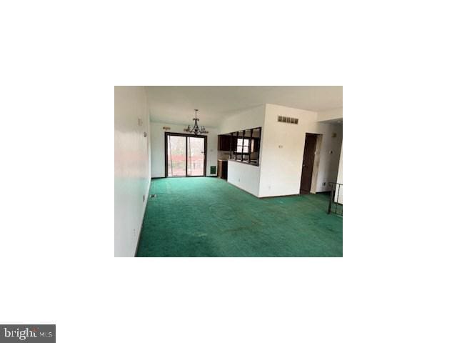 unfurnished room featuring a chandelier, carpet flooring, and visible vents