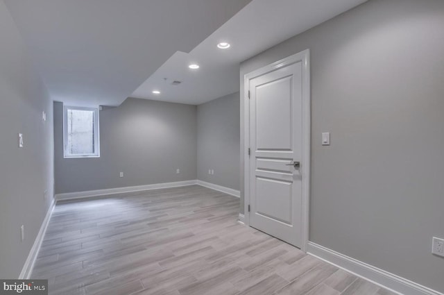 interior space featuring recessed lighting, baseboards, and light wood finished floors