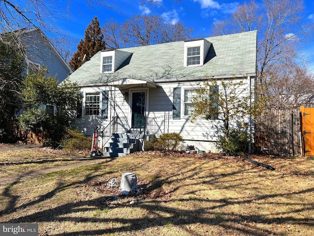 cape cod-style house with fence