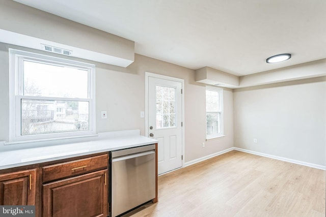 kitchen featuring light wood finished floors, baseboards, visible vents, light countertops, and stainless steel dishwasher