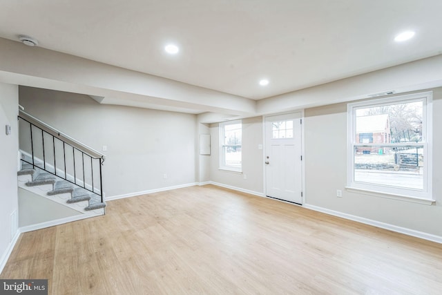 entryway with wood finished floors, baseboards, and stairs