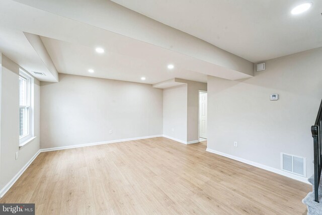 basement with light wood-style flooring, visible vents, baseboards, and recessed lighting