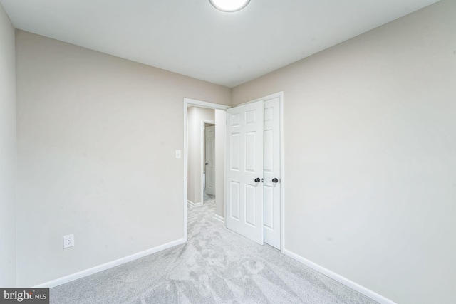 unfurnished bedroom featuring carpet, a closet, and baseboards