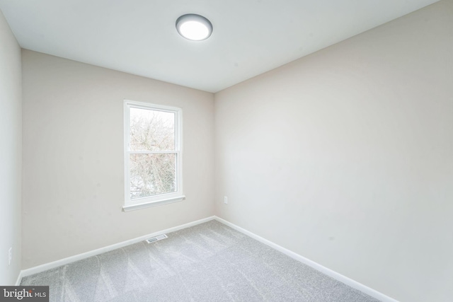 carpeted empty room featuring visible vents and baseboards