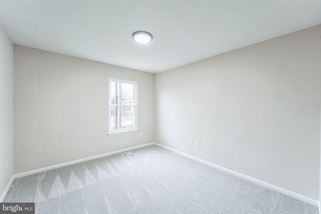 carpeted spare room with baseboards