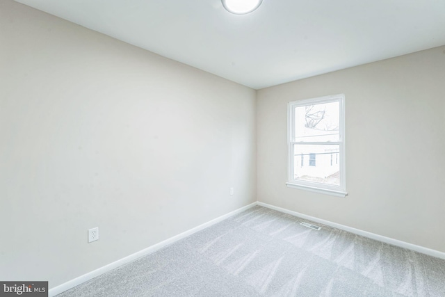 spare room with baseboards, visible vents, and carpet flooring