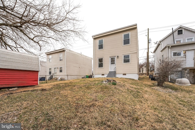 back of house featuring entry steps, crawl space, and a yard