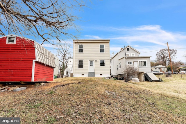 rear view of house featuring entry steps, a yard, and crawl space