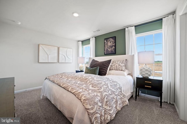 carpeted bedroom with visible vents and baseboards