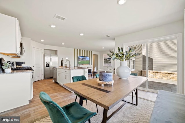 dining room with light wood-style floors, visible vents, and recessed lighting