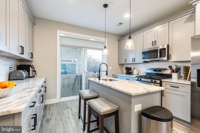 2525 N Hancock St, Philadelphia, PA 19133 - kitchen with visible vents, appliances with stainless steel finishes, light wood-style floors, a kitchen island with sink, and a sink