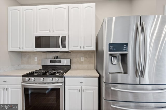 kitchen featuring stainless steel appliances, tasteful backsplash, light countertops, and white cabinets