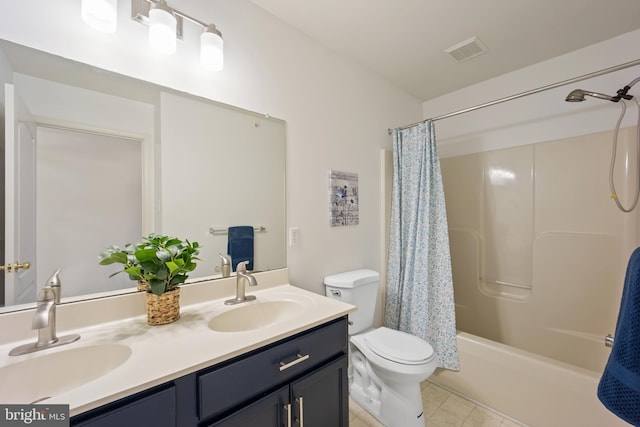 bathroom with toilet, double vanity, a sink, and visible vents