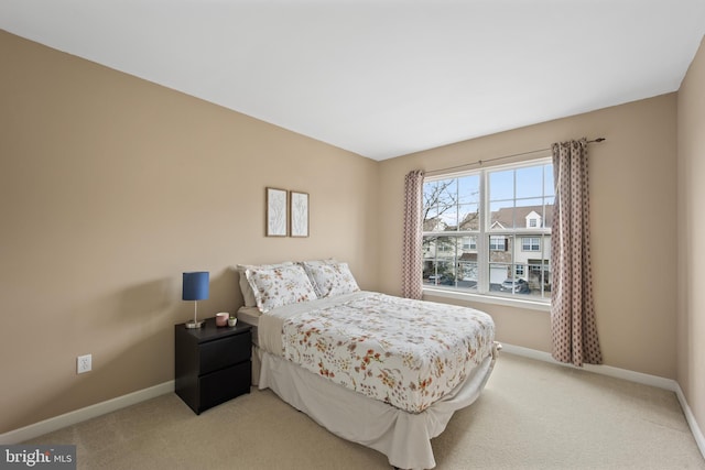 bedroom featuring light colored carpet and baseboards