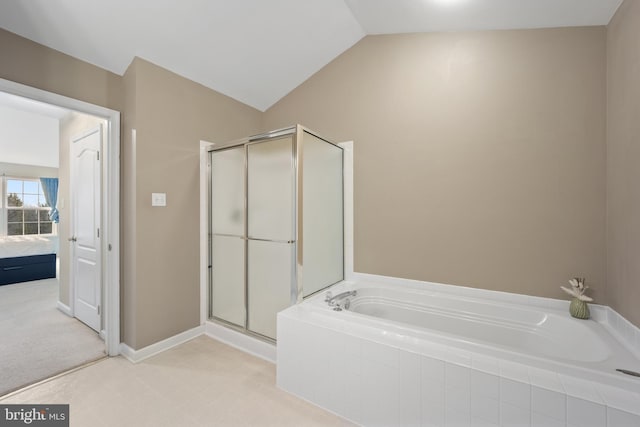 bathroom featuring a garden tub, a shower stall, baseboards, and vaulted ceiling