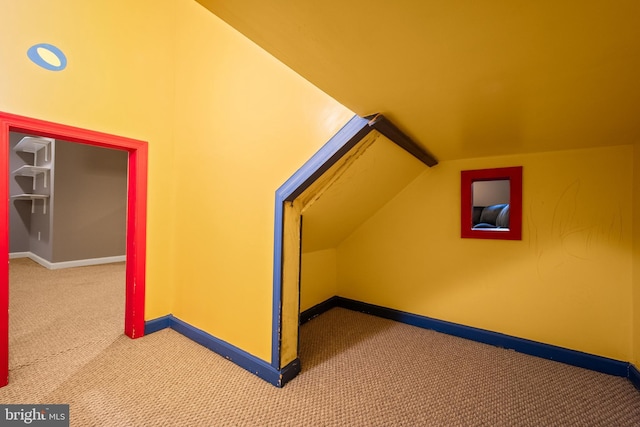 additional living space with carpet, baseboards, and vaulted ceiling