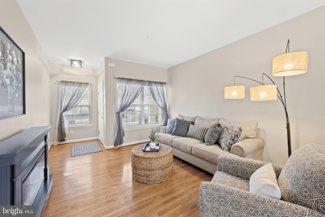 living area with light wood-type flooring and baseboards