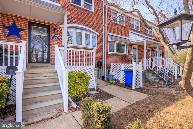 view of exterior entry featuring brick siding