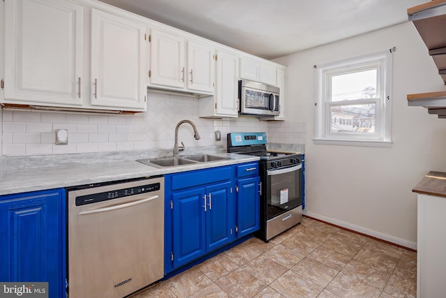 kitchen with decorative backsplash, blue cabinets, stainless steel appliances, white cabinetry, and a sink