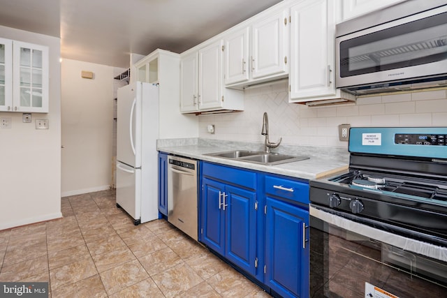 kitchen featuring white cabinets, appliances with stainless steel finishes, blue cabinets, light countertops, and a sink