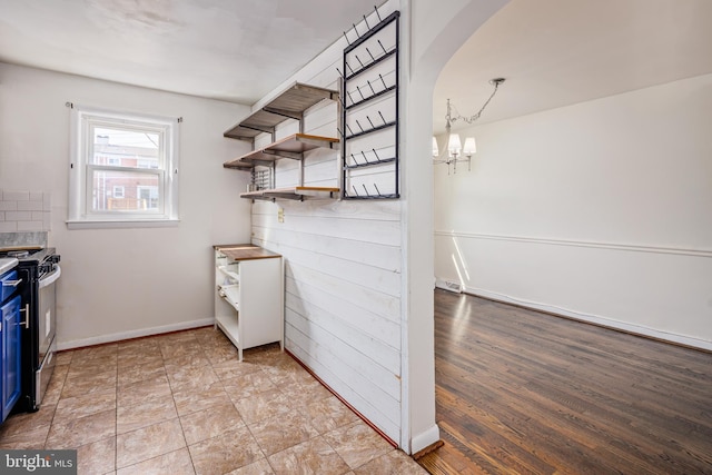 interior space with an inviting chandelier, baseboards, and arched walkways