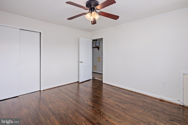 unfurnished bedroom with a closet, crown molding, baseboards, and wood finished floors